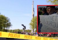 Latvietis ar plakātu rokās protestē Uzvaras parkā – viņa virzienā izskan daudzi nikni vārdi